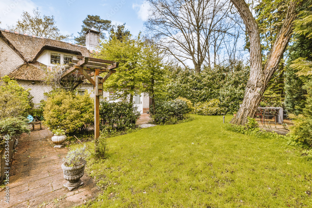 a backyard with lots of trees and bushes in the yard, surrounded by lush green grass there is a stone path that leads up