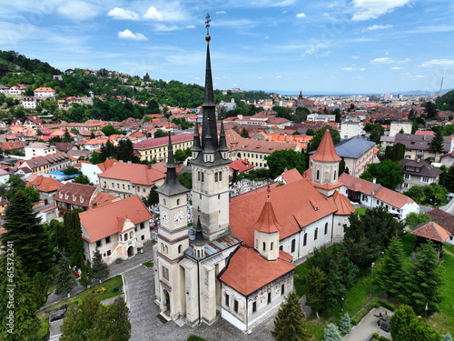 An overhead perspective of the Saint Nicholas Orthodox Church, landmark in Brașov, Romania, showcasing its architectural features and surrounding urban landscape.