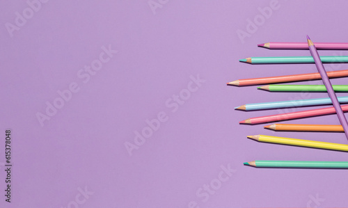 Colored pastel encils on lilac violet background. Back to School or drawing and creativity concept. Copy space. Top view banner photo