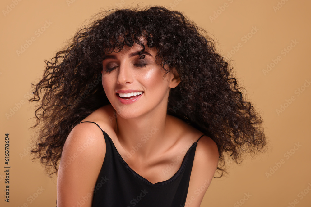 Beautiful young woman with long curly hair on beige background Beautiful young woman with long curly hair on beige background