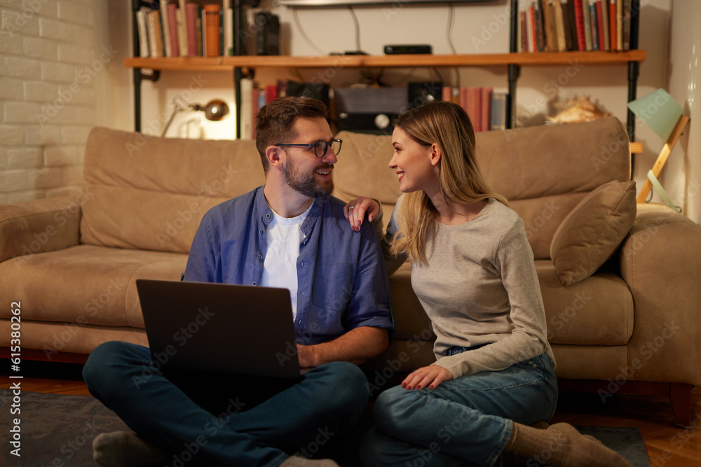 Young couple spending evening at home using laptop Young couple spending evening at home using laptop