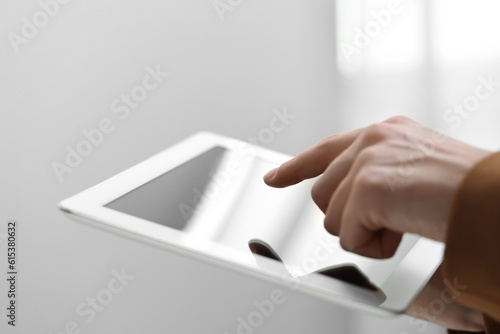 Closeup view of woman using modern tablet on blurred background