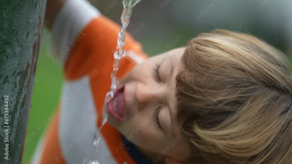 One little boy drinking water from public faucet at park. Child drinks refreshing water outdoors One little boy drinking water from public faucet at park. Child drinks refreshing water outdoors