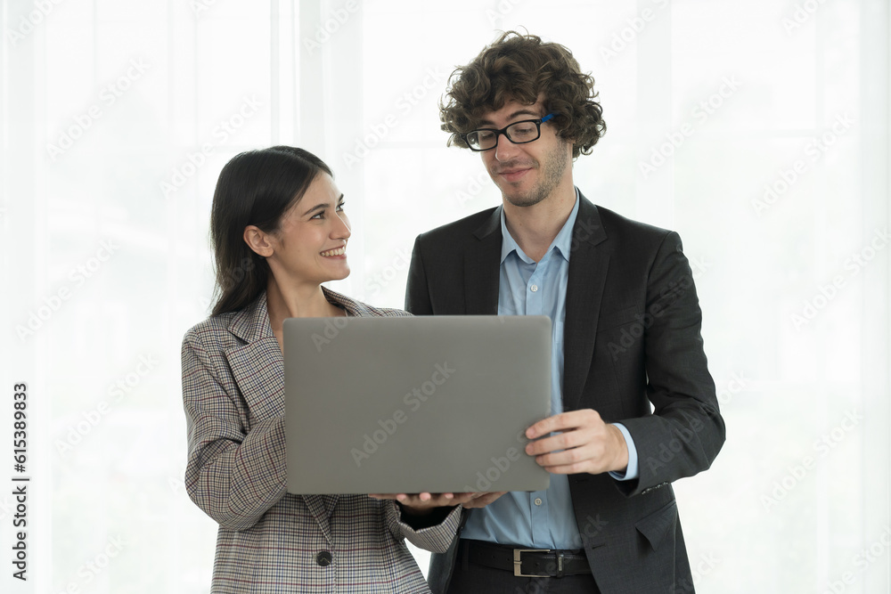 Obraz premium Portrait of young businessman and business woman standing, discussion, meeting together in office. Business people and office concept
