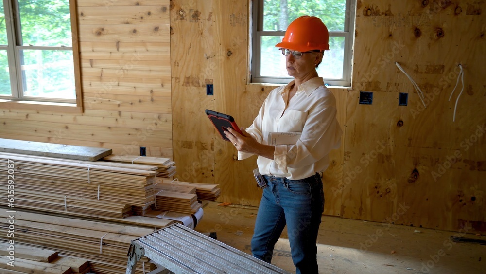 Woman architect with hard hat doing walkthrough inspection of new house construction with computer tablet. Woman architect with hard hat doing walkthrough inspection of new house construction with computer tablet.