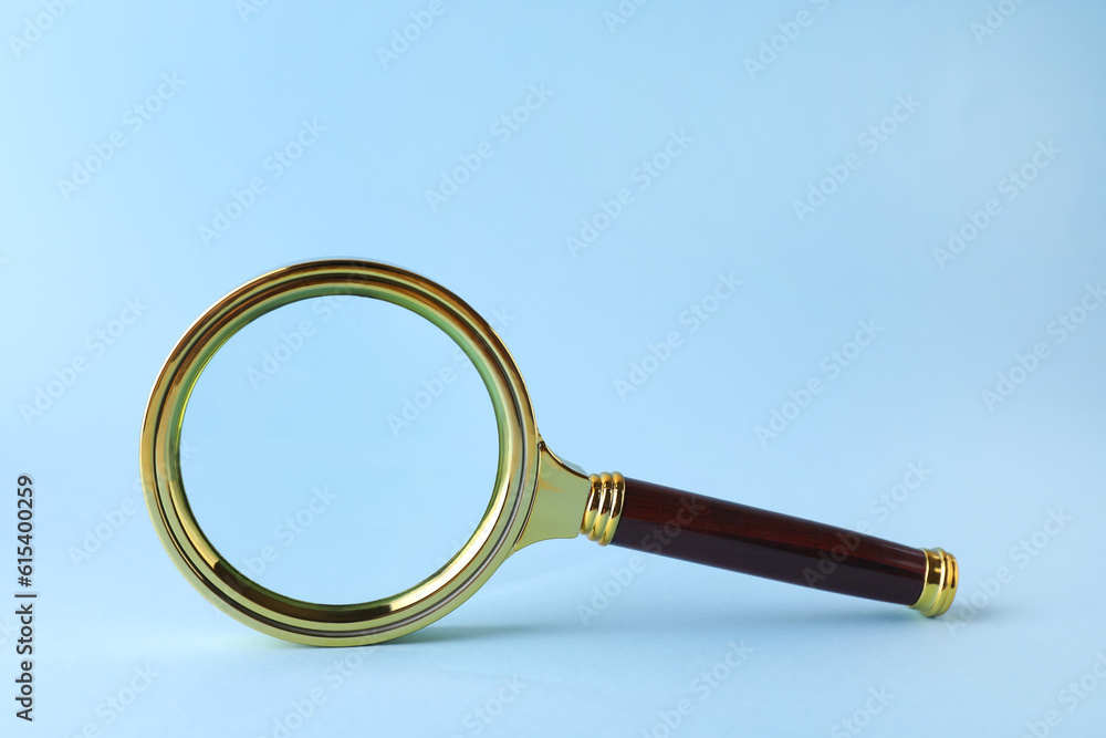 Magnifying glass with handle on light blue background Magnifying glass with handle on light blue background