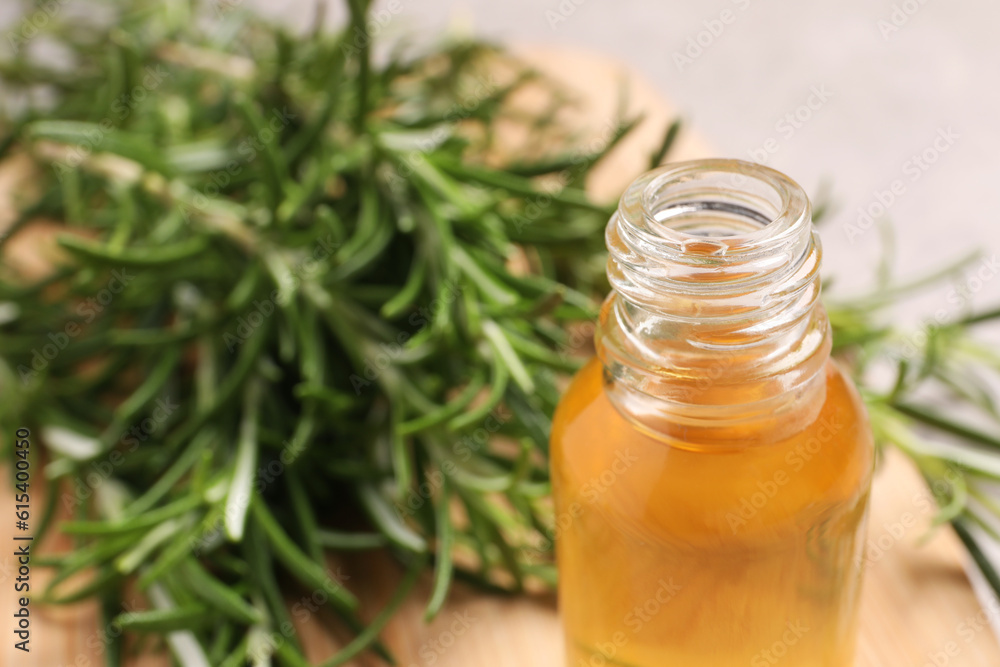 Bottle of rosemary oil on blurred background, closeup. Space for text Bottle of rosemary oil on blurred background, closeup. Space for text