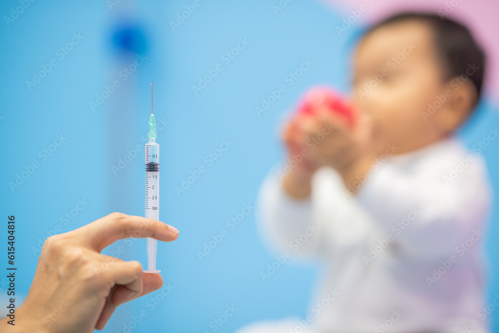 pediatrician Hand hold vaccine liquid injection in syringe for injecting child baby infant. small syringe needle for infant prevention flu by vaccination immunity in Pediatrics hospital clinic. pediatrician Hand hold vaccine liquid injection in syringe for injecting child baby infant. small syringe needle for infant prevention flu by vaccination immunity in Pediatrics hospital clinic.
