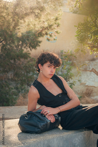 Young fashionable man in black clothes posing in a park