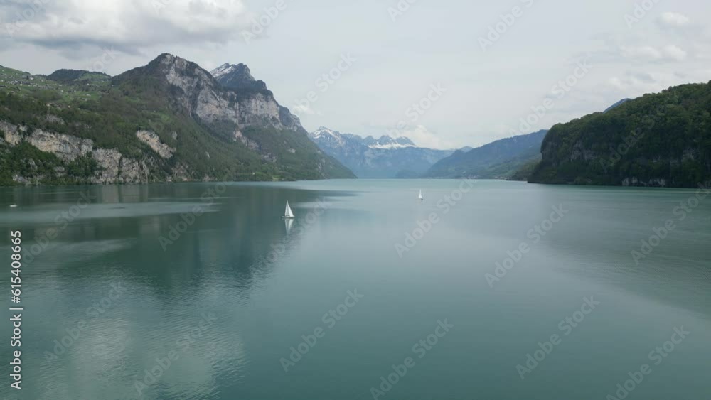 Calm waters of Switzerland lake with yachts sailing creating tranquil scene Calm waters of Switzerland lake with yachts sailing creating tranquil scene