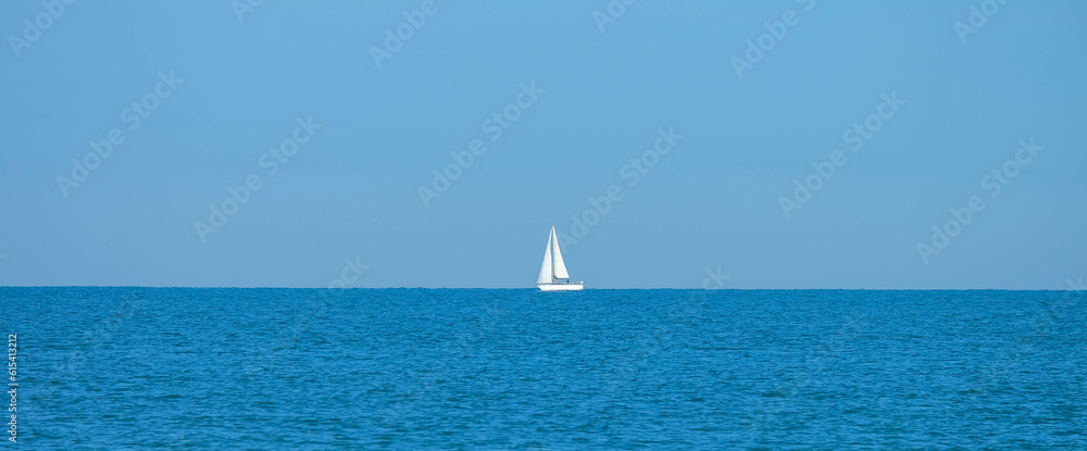 Strand von Viareggio in Italien mit Segelboot am Horizont
