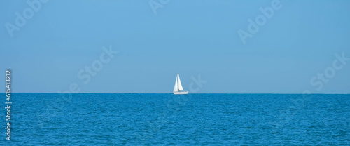 Strand von Viareggio in Italien mit Segelboot am Horizont