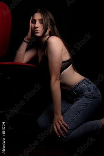 Beautiful young girl in a white shirt and jeans on a black background © Олег Мальшаков