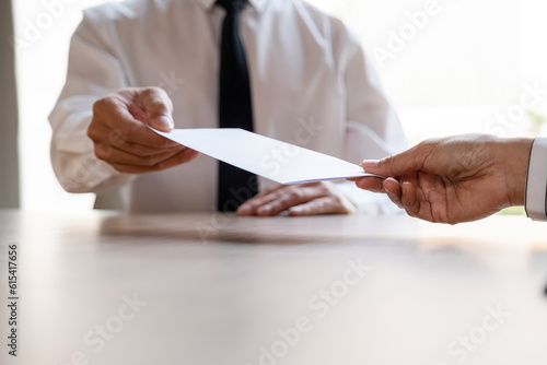 Businessman give resignation letter to boss.