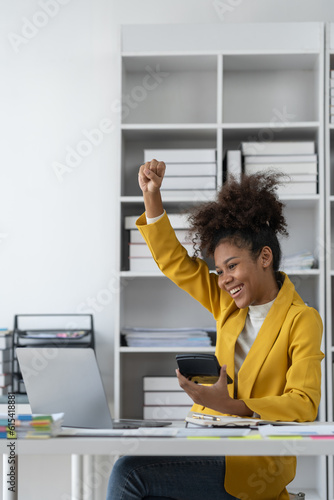 African american businesswoman expressing excitement and happiness Glad to win successful online financial business on office laptop.