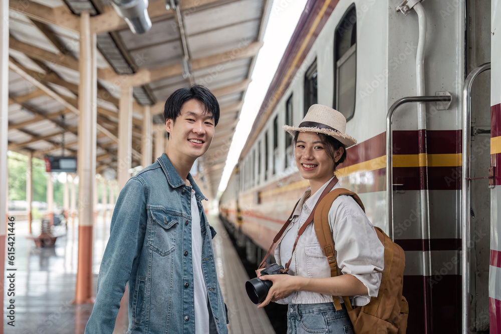 Asian couple travelers, backpack travelers, together at train station platform. tourism activity or railroad trip traveling concept