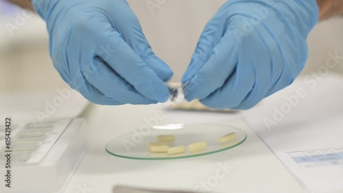 Crop pharmacist taking capsules out of plate