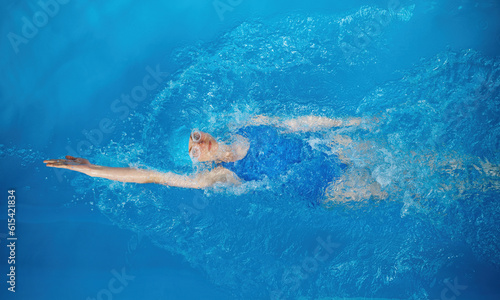 High angle of professional sportswoman swimming in backstroke photo
