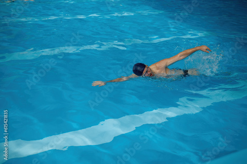 Professional senior man swimmer doing exercise in indoor swimming pool