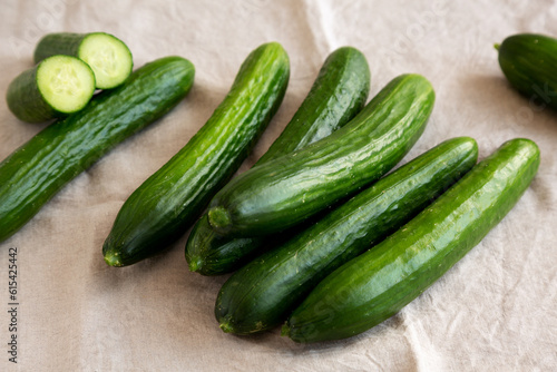 Organic Mini Baby Cucumbers on a white wooden background, side view.