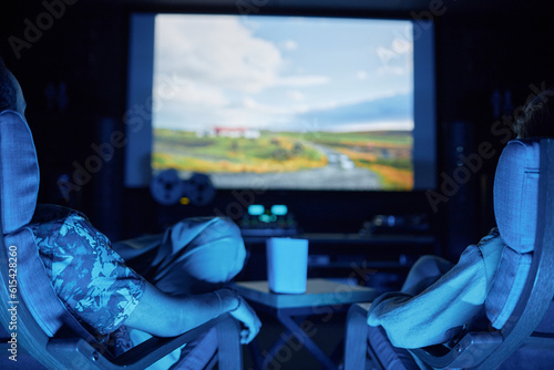 Bild auf Leinwand Back view of couple watching movie together on big screen in home cinema