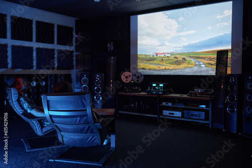 Canvas-taulu Wide angle view of couple watching movie together on big screen in home cinema,