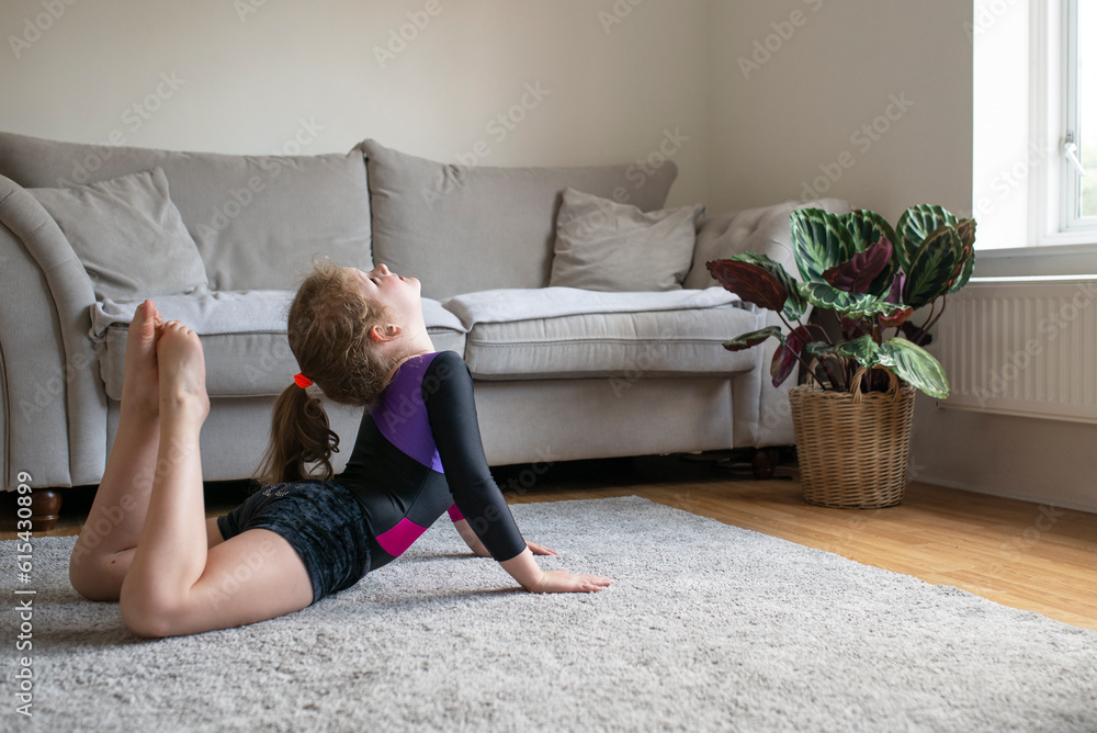 Pretty young girl in gymnastics leotard sportswear doing fitness exercises at home, yoga, stretching Pretty young girl in gymnastics leotard sportswear doing fitness exercises at home, yoga, stretching