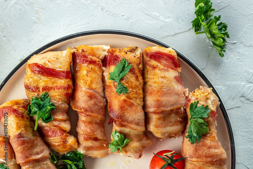 Delicious chicken rolls wrapped in strips of bacon on a cast-iron frying pan. Concept healthy and balanced eating. place for text, top view