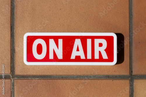 Fotografi billboard signboard or indicator sign with the word on air written in white on a red background