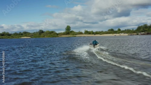 Dynamic aerial footage of a fast motor boat sailing along the Volga River in Russia on a sunny and warm summer day, splashing water, summer nature photo