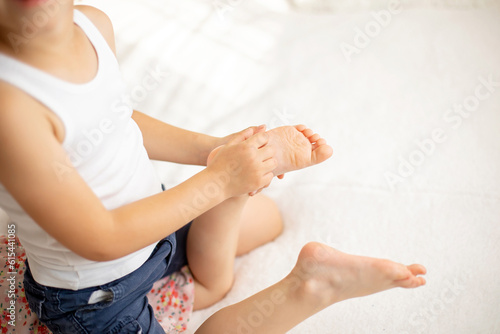 Photos Cute sweet toddler children, tickling feet on the bed, laughing and smiling
