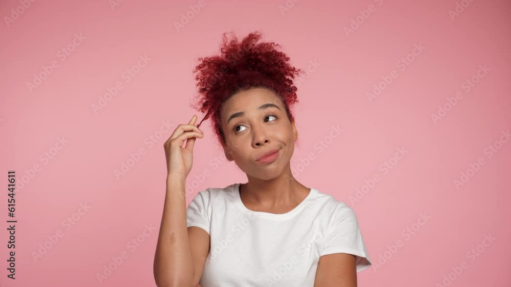 Close up thoughtful smiling African American redhead curly woman in white t-shirt looks away thinking. Portrait pensive positive beautiful female standing on isolated pink background with copy space Close up thoughtful smiling African American redhead curly woman in white t-shirt looks away thinking. Portrait pensive positive beautiful female standing on isolated pink background with copy space