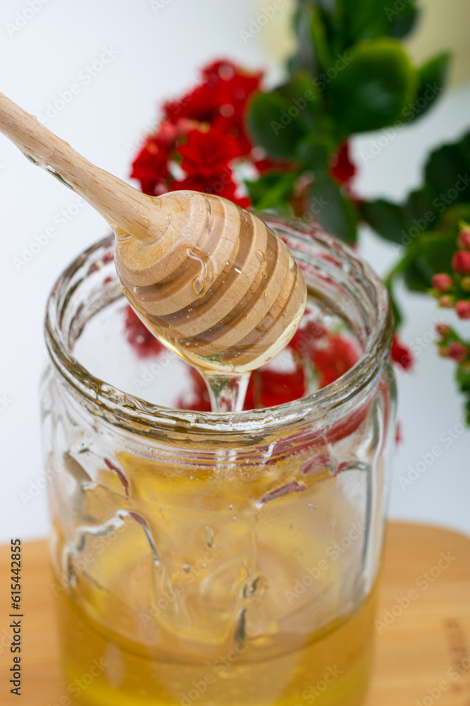 Wooden spoon with bee honey in glass jar Wooden spoon with bee honey in glass jar