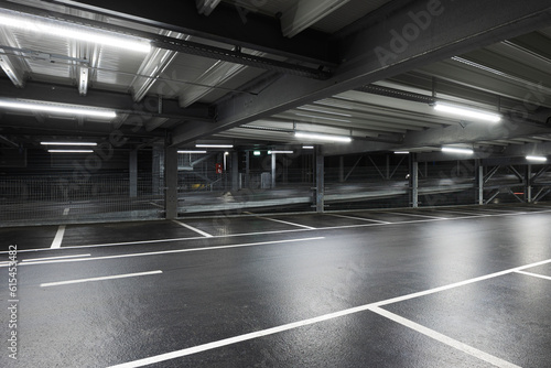 Modern underground garage with lamps illuminating the scene. Parking lines are drawn on the floor. No one inside