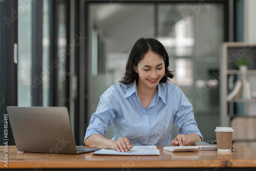 Confident businesswoman working using calculator to calculate profit financial investment document in real estate business project for analyzing reports, data recording and management system concept © crizzystudio