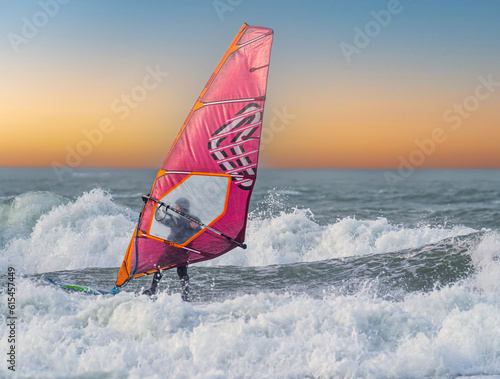Windsurfing on Broad Haven Beach, Pembrokeshire.  A skilled windsurfer glides effortlessly through the powerful waves of Broad Haven Beach, Pembrokeshire, Wales on a stunning day.