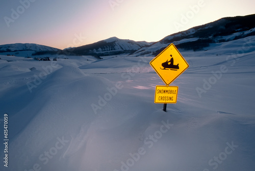 'Snowmobile Crossing' sign in a snowdrift; Crested Butte, Colorado, United States of America