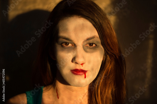 Artificial blood streams from the mouth and nose of a woman with zombie like makeup; Lincoln, Nebraska, United States of America photo