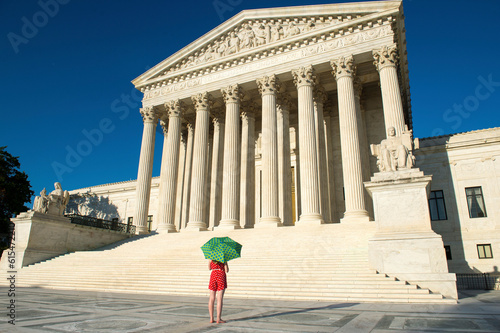 Woman with umbrella in vibrant color views the U.S. Supreme Court in Washington, DC, USA; Washington, District of Columbia, United States of America photo