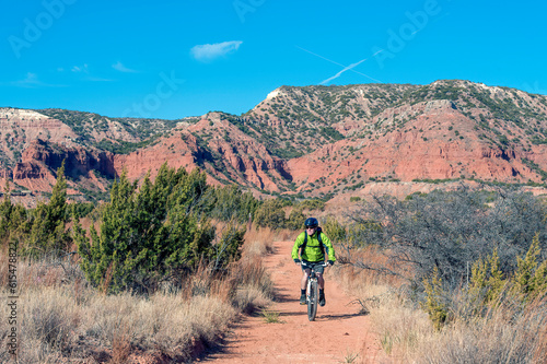 Man cycling through Caprock Canyons State Park and Trailway in Texas, USA; Quitaque, Texas, United States of America photo