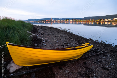 Moored rowing skiff in vibrant yellow on the shore at the water's edge near the town of Cheticamp; Cabot Trail, Cape Breton Island, Nova Scotia, Canada photo