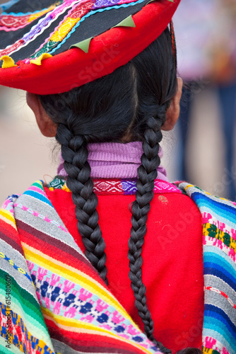 Rear view of a young girl with braids in traditional Peruvian clothing; Sacred Valley, Peru photo