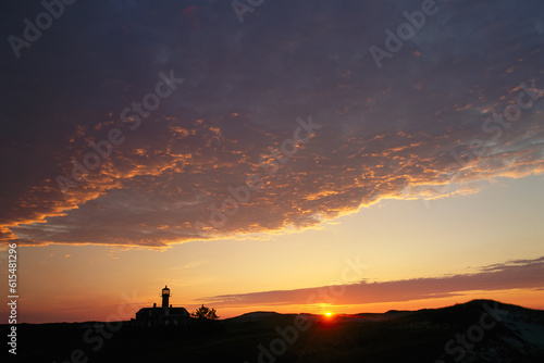 Lighthouse on Monomoy Island silhouetted by the setting sun, Cape Cod, Massachusetts, USA; Cape Cod, Massachusetts, United States of America photo