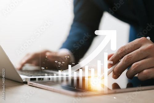 Fotomurale Businessman use laptop and tablet analyzing company growth, future business growth arrow graph, development to achieve goals, business outlook, financial data for long term investment