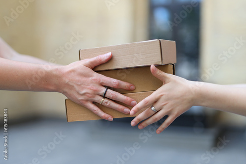 Transfer of parcels or cardboard boxes from one hand to another. © Andrii Zastrozhnov