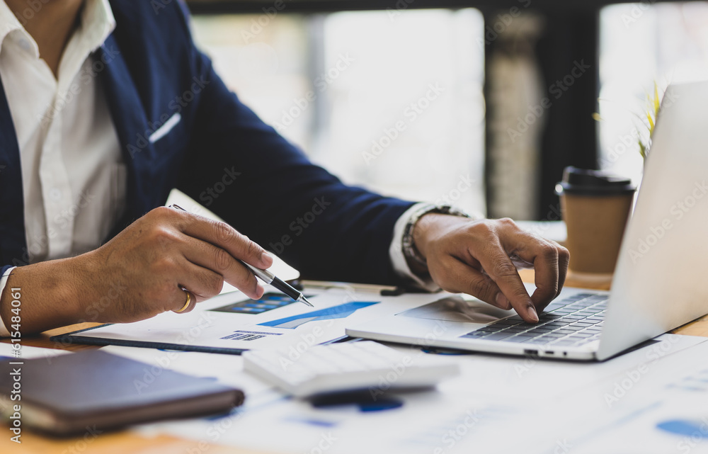 Businessman working on documents on the desk, data analysis of financial figures on laptop and business investments planning. Businessman working on documents on the desk, data analysis of financial figures on laptop and business investments planning.