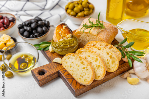 Italian ciabatta bread with olives, garlic, parmesan and rosemary on a light concrete background. Tasty food. Aperitif. Place for text. copy space. Delicacy. Bon appetit.
