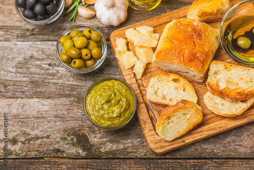 Italian ciabatta bread with olives, garlic, parmesan and rosemary on texture wooden background. Tasty food. Aperitif. Place for text. copy space. Delicacy. Bon appetit.