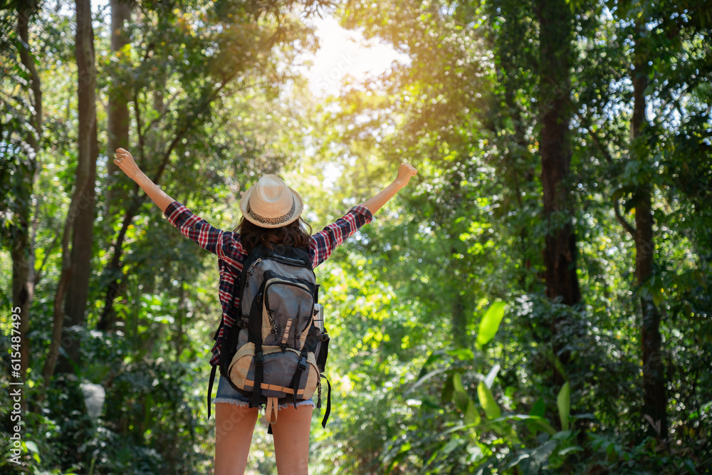 Asian woman tourist carrying a backpack Put on your hat and go for a tropical hiking. summer nature tourism. happy long weekend activities. concept holiday travel