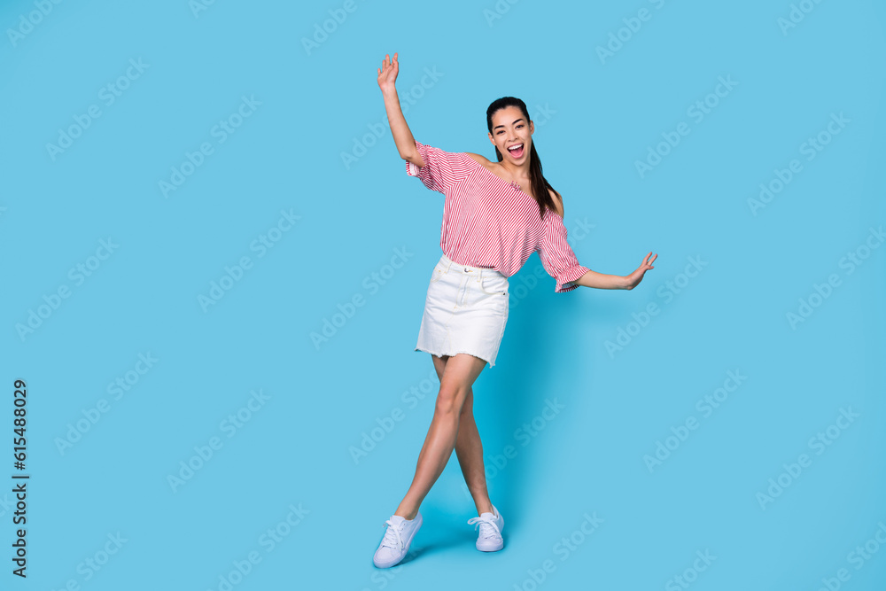 Full length photo of funky positive girl dressed off shoulders striped blouse having fun dancing empty space isolated blue color background